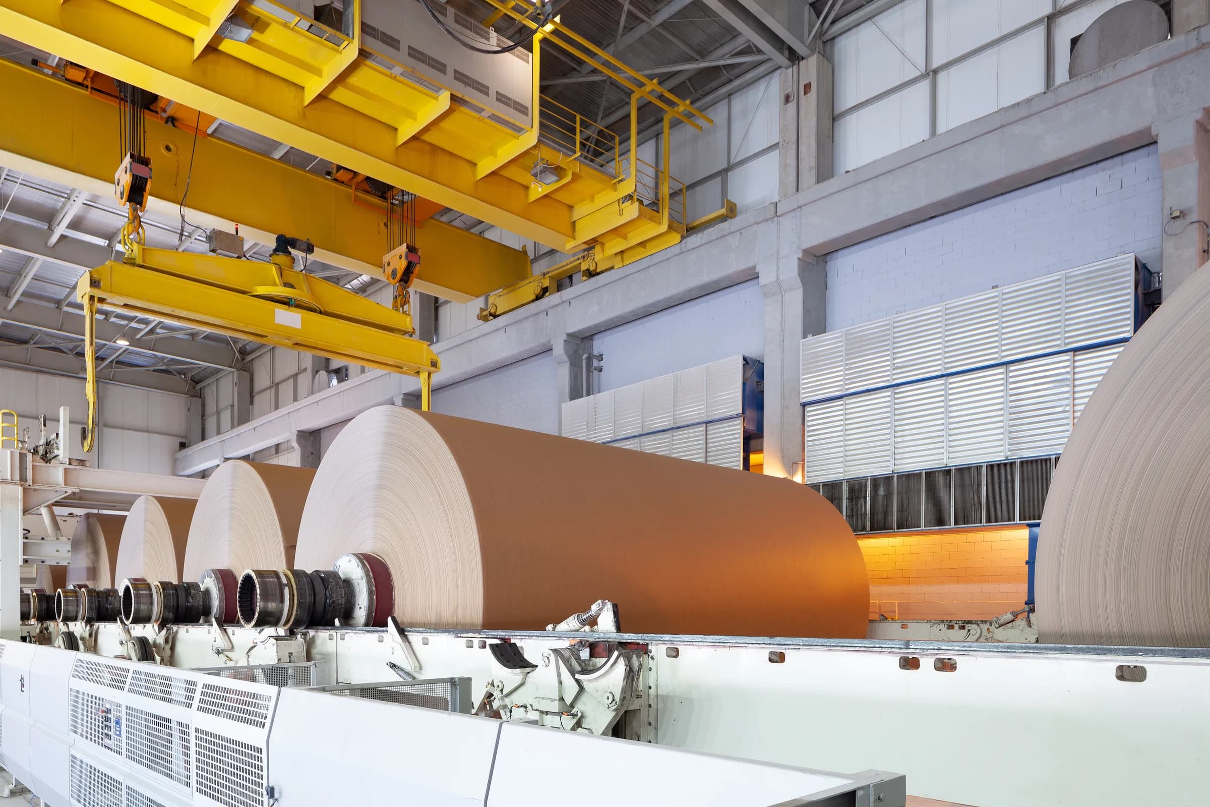 Bobine di carta da cartone al riavvolgitore, sotto il carroponte